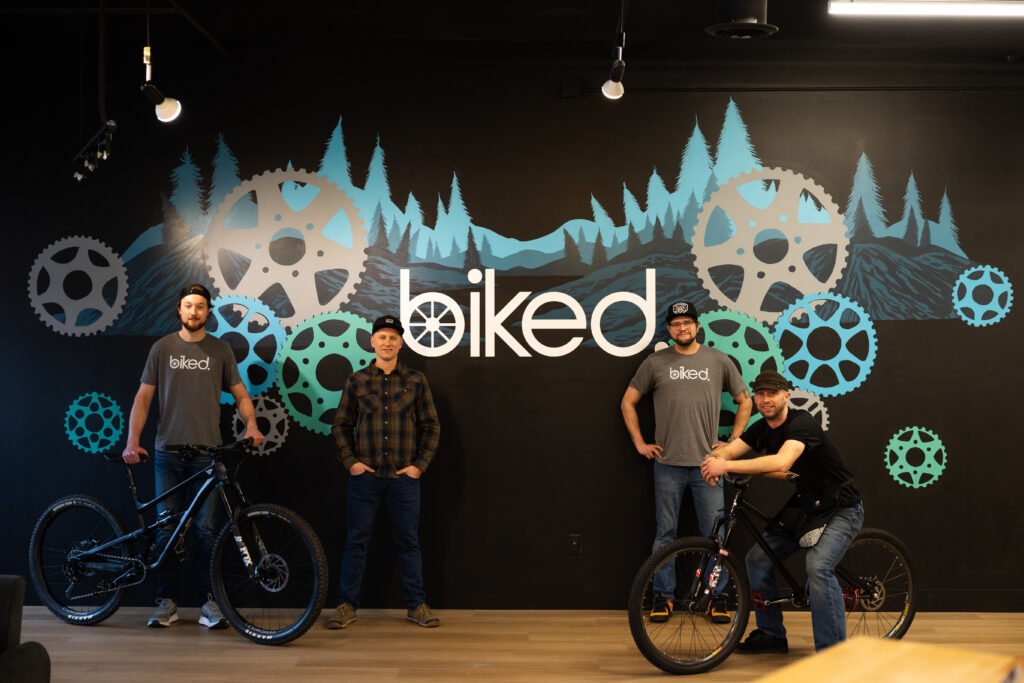 Biked team members in front of mural at their Grand Rapids bike shop
